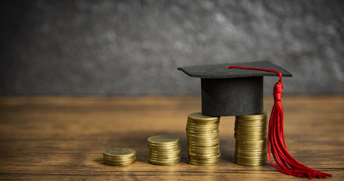 Scholarships education concept with graduation cap on coin money saving for grants education on wooden table dark background