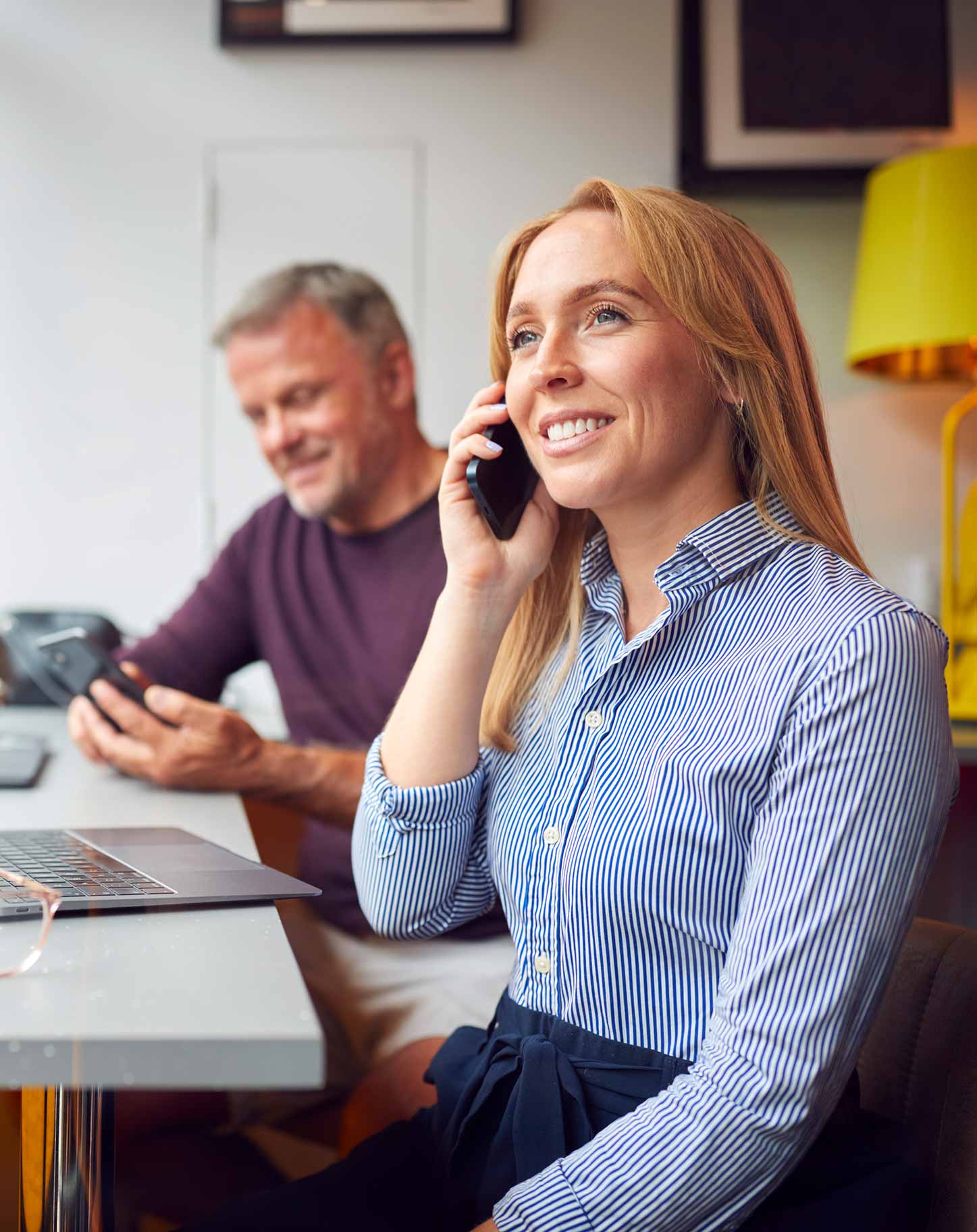 Senior woman smiling while speaking with a Medicare advisor on the phone