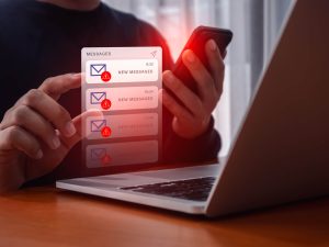 SMS scam or fake text message phishing concept. System hacked warning alert, email hack, scam malware spreading virus on messages alert virtual on mobile smart phone screen in person people hand
