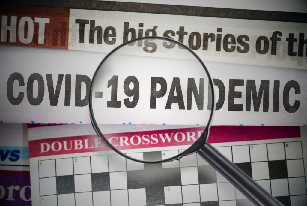 COVID-19 newspaper clippings with a magnifying glass