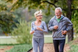 Fitness routines for elderly people. Working out together. Exercise to stop aging. Cheerful active senior couple jogging in the park