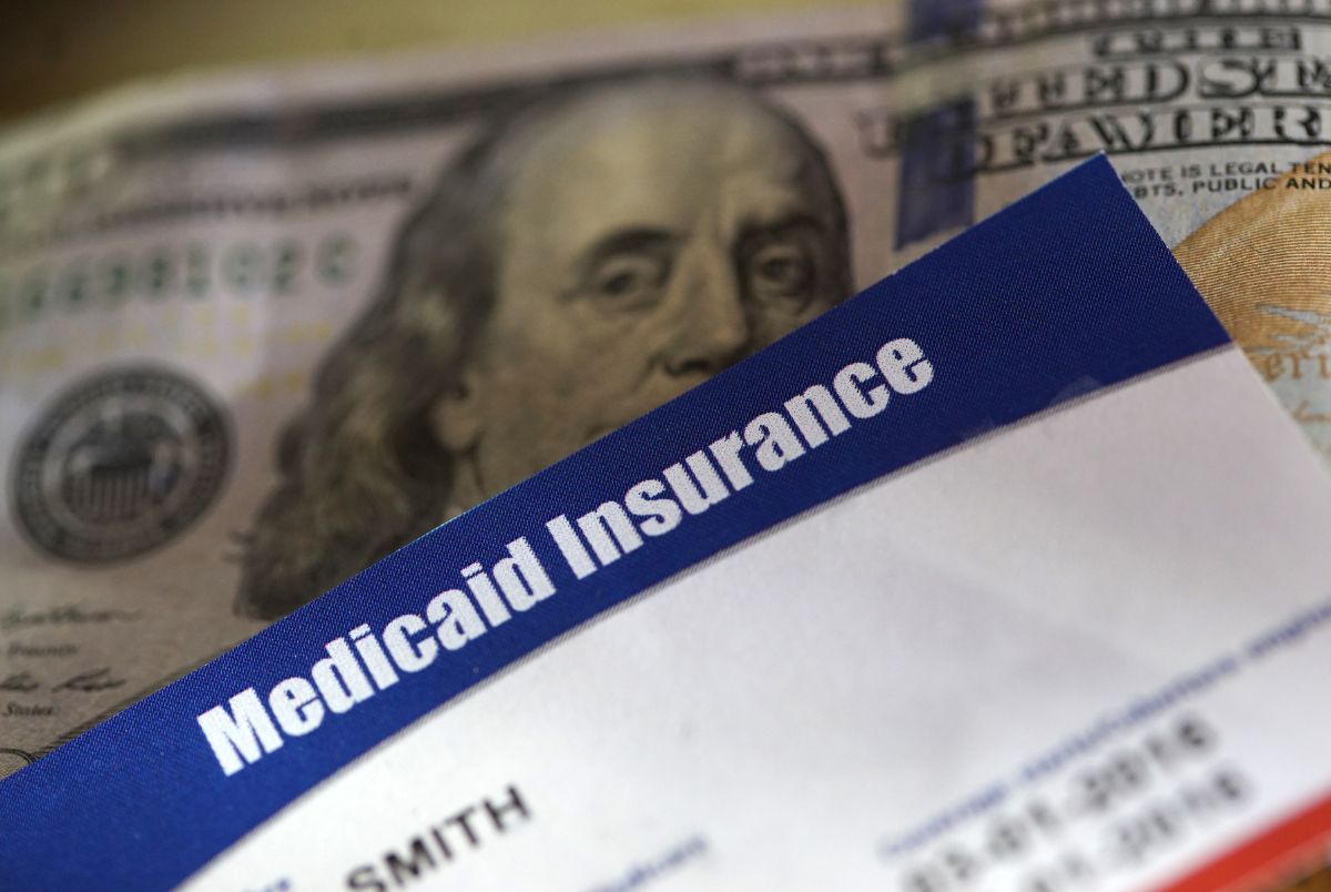 Stock image of a medicaid card on top of money