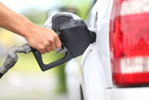 Pumping gas at gas pump. Closeup of man pumping gasoline fuel in car at gas station.
