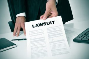 lawyer holding legal documents with the word "lawsuit" in bold letters at the top