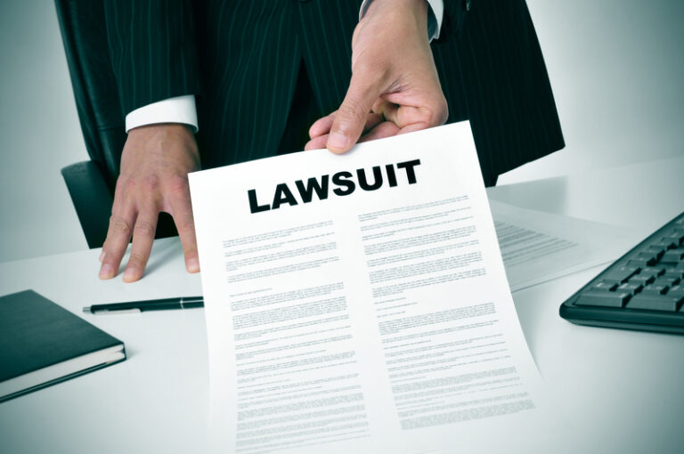 lawyer holding legal documents with the word "lawsuit" in bold letters at the top