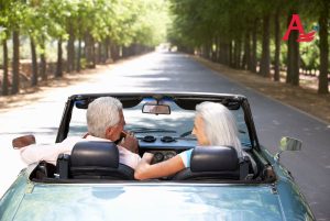 Senior couple driving a convertible