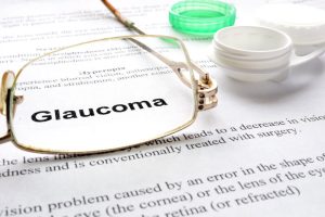 Paper with words glaucoma, glases and container for lenses. Eye disorders.