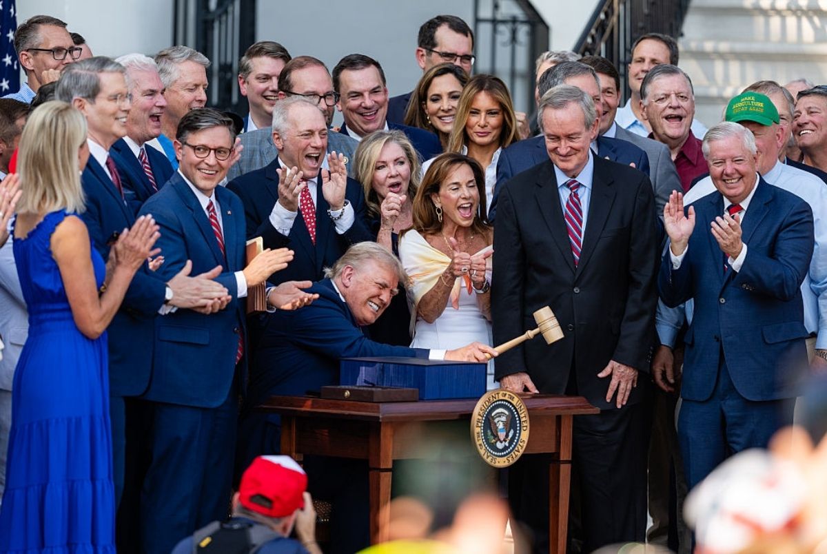 WASHINGTON, DC - JULY 04: U.S. President Donald Trump, joined by Republican lawmakers, holds a gavel after signing the "One, Big Beautiful Bill" Act into law during an Independence Day military family picnic on the South Lawn of the White House on July 04, 2025 in Washington, DC. After weeks of negotiations with Republican holdouts Congress passed the "One, Big Beautiful Bill" Act into law, President Trump's signature tax and spending bill. The bill makes permanent President Donald Trump's 2017 tax cuts, increase spending on defense and immigration enforcement and temporarily cut taxes on tips, while cutting funding for Medicaid, food assistance and other social safety net programs. (Photo by Eric Lee/Getty Images)