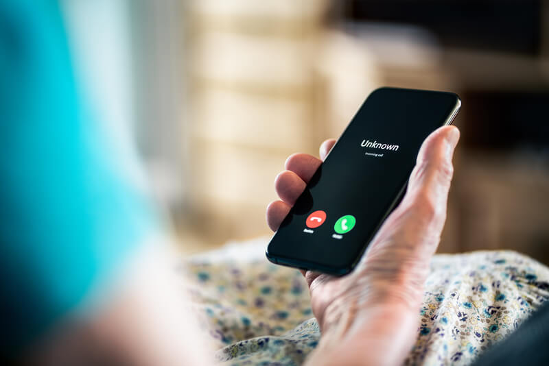 senior scams, woman on phone with unknown caller