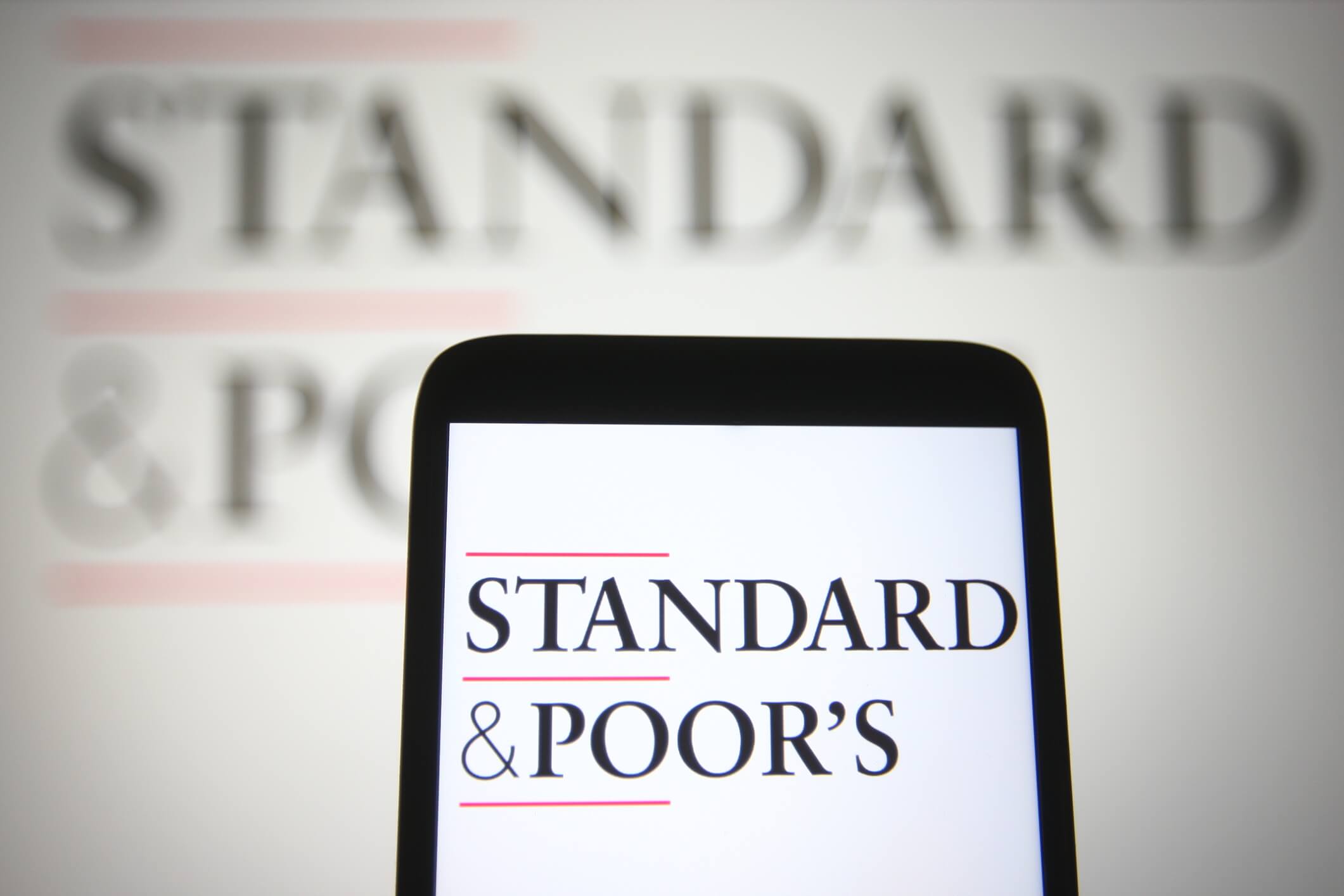 KYIV, UKRAINE - SEPTEMBER 12, 2021: In this photo illustration Standard & Poor`s logo is seen on a mobile phone and a computer screen