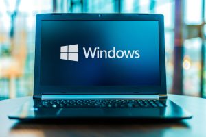 POZNAN, POL - MAR 24, 2020: Laptop computer displaying logo of Windows, a group of several graphical operating system families, all of which are developed, marketed and sold by Microsoft
