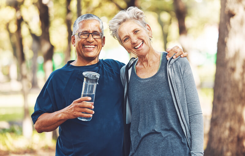 Portrait, exercise and senior couple with water bottle for training, workout and park. Mature man, old woman and. Mature man, old women and hydration for practice, cardio and energy for wellness, health and fitness in nature.