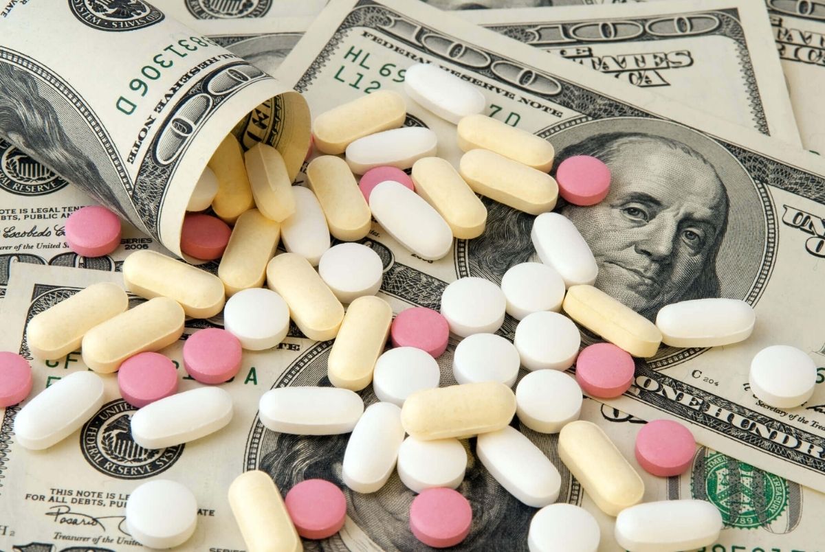 Pills and money. Pills of different colors on money background.