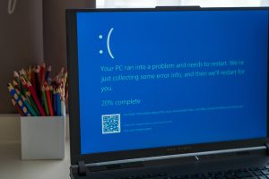 Prague, Czech Republic - September 11, 2024: Blue screen of death on a laptop at home office. Prague, Czech Republic - September 11, 2024: A laptop displays the blue screen of death while in use at a home office desk, signaling a system crash. The workspace is organized using pencils.