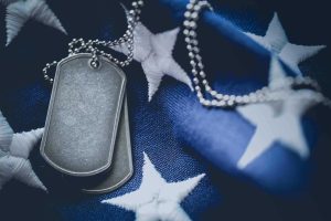 Worn USA military dog tags close up on US American flag with blank space for text
