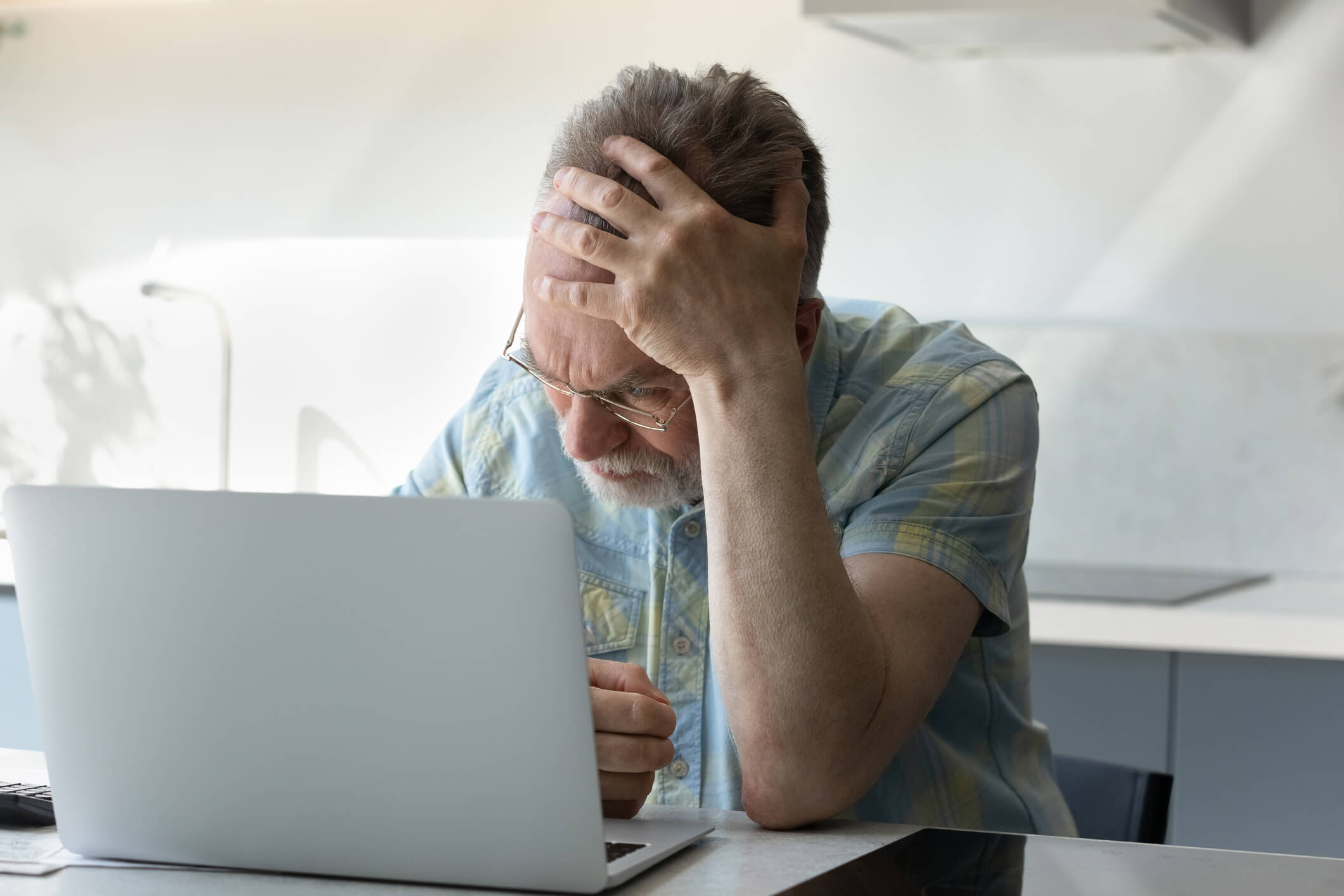 Upset senior man worried about finance safety. Upset senior 60 - 70s aged man worried about finance safety data, online payment security. Mature retired grey haired male bank client concerned about problem with credit card, financial fraud threat