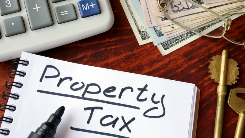 Property tax written in a notebook. Property tax written in a notebook and calculator.