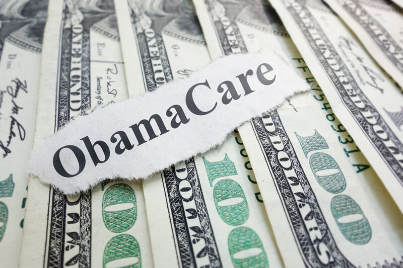 Closeup of an Obamacare newspaper headline on cash