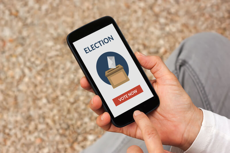 Hands holding smart phone with online voting concept on screen