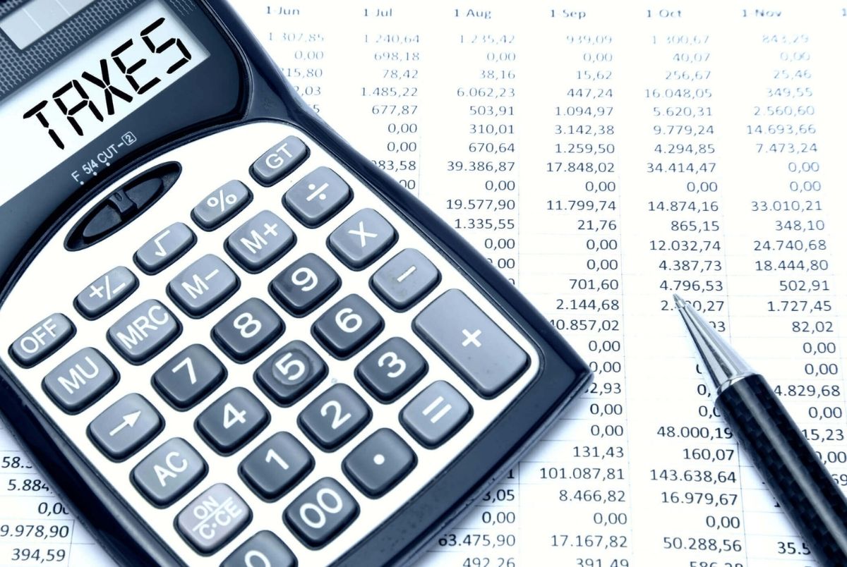 Calculator with TAXES text with calculation sheet background