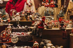 various Christmas decorations for sale, including snow globes, stuffed figures, and ornaments.