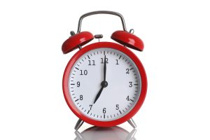 Red alarm clock isolated on white background. Medicare annual enrollment period ends december 7.