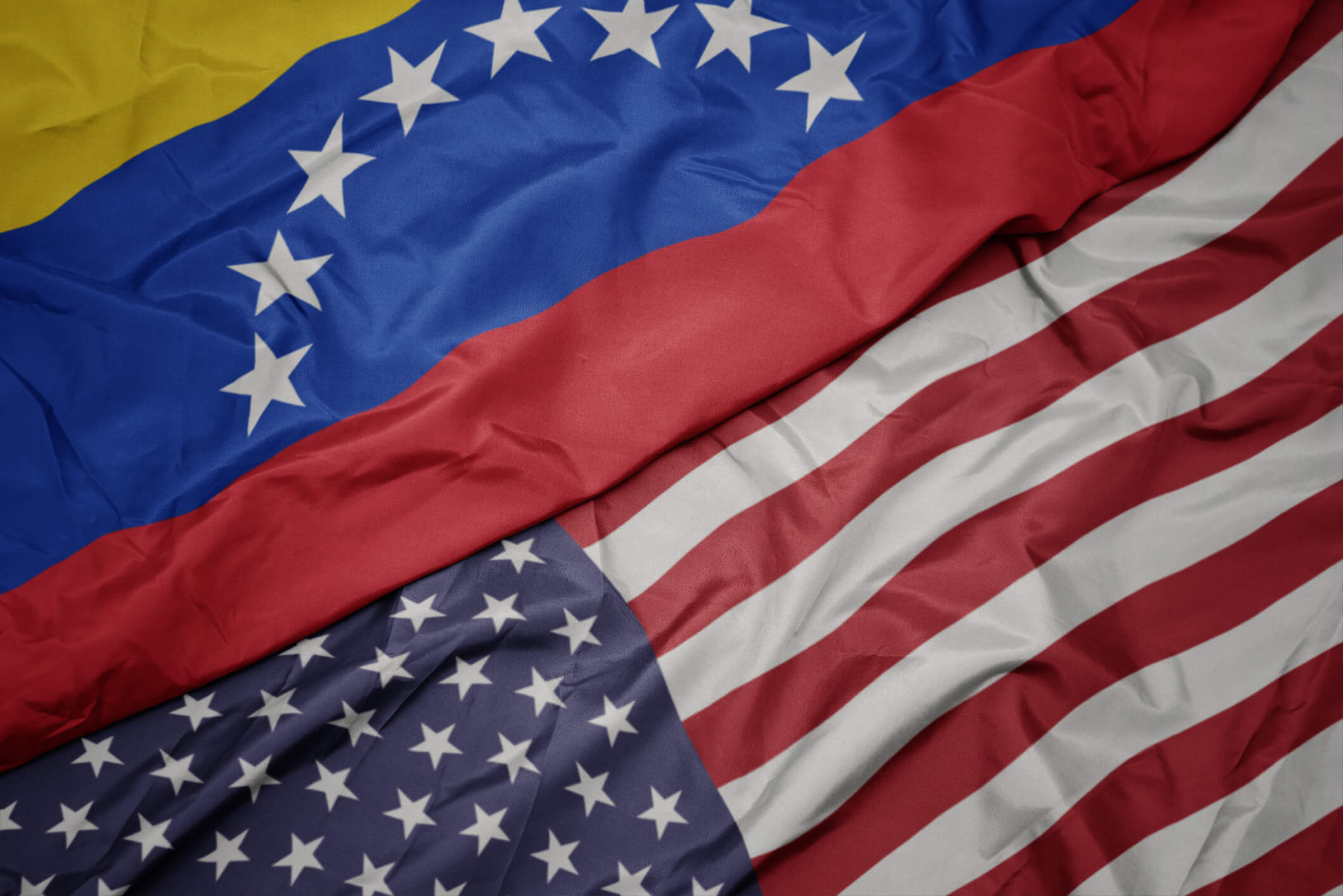 Waving colorful flag of united states of america and national flag of venezuela. macro