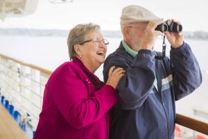 Adventurous Senior Couple Sightseeing on The Deck of a Cruise Ship. Happy Senior Couple Enjoying The View From Deck of a Luxury Passenger Cruise Ship.