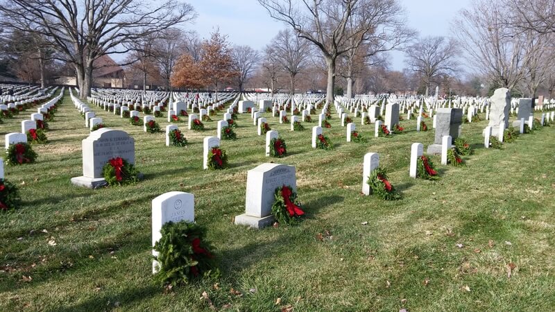 Wreaths Across America Arlington National Cemetery. Wide shot of graves with wreaths during Wreaths Across America at Arlington National Cemetery in Virginia