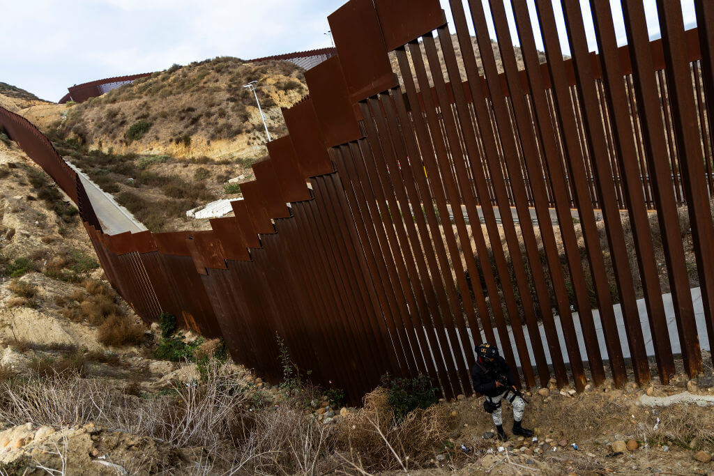 TIJUANA, MEXICO - FEBRUARY 5: A National Guard officer monitors the border wall between Mexico and the U.S. during the deployment of National Guard troops at the U.S. Border on February 5, 2025 in Tijuana, Mexico. President Claudia Sheinbaum announced the deployment of 10,000 troops along the Mexico-U.S. border as part of an agreement with Trump's administration to delay an increase of 25% tariffs on exported goods. (Photo by Francisco Vega/Getty Images)