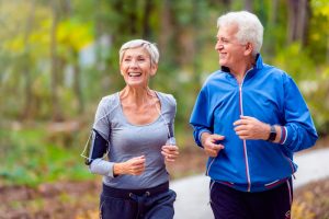 Smiling senior couple jogging in the park. Smiling senior active couple walking, jogging and talking in the park.
