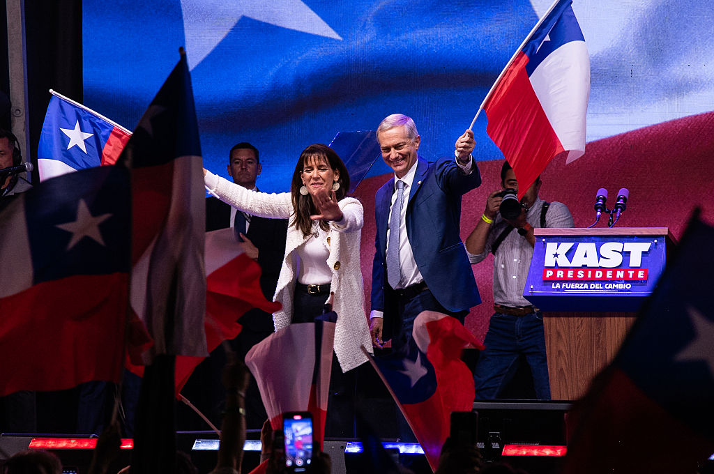 SANTIAGO, CHILE - DECEMBER 14: Presidential candidate Jose Antonio Kast of the "Partido Republicano" and his wife Maria Pia Adriazola wave Chilean flags following the 2025 presidential election runoff on December 14, 2025 in Santiago, Chile. According to the Chilean electoral institute 'Servel', Kast has 58.21% of the votes against 41.79% for Jeannette Jara of the "Unidad Por Chile" Coalition, after 98.53% of the polling stations counted in the Presidential election runoff.(Photo by Claudio Santana/Getty Images)