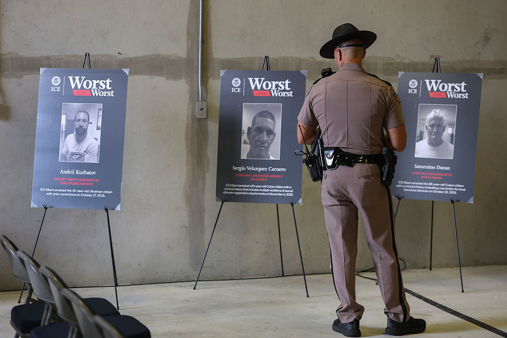 A Florida Highway Patrol officer looks at pictures of alleged criminal aliens before a press conference at the ICE, Enforcement and Removal Operations building on November 13, 2025 in Miramar, Florida.