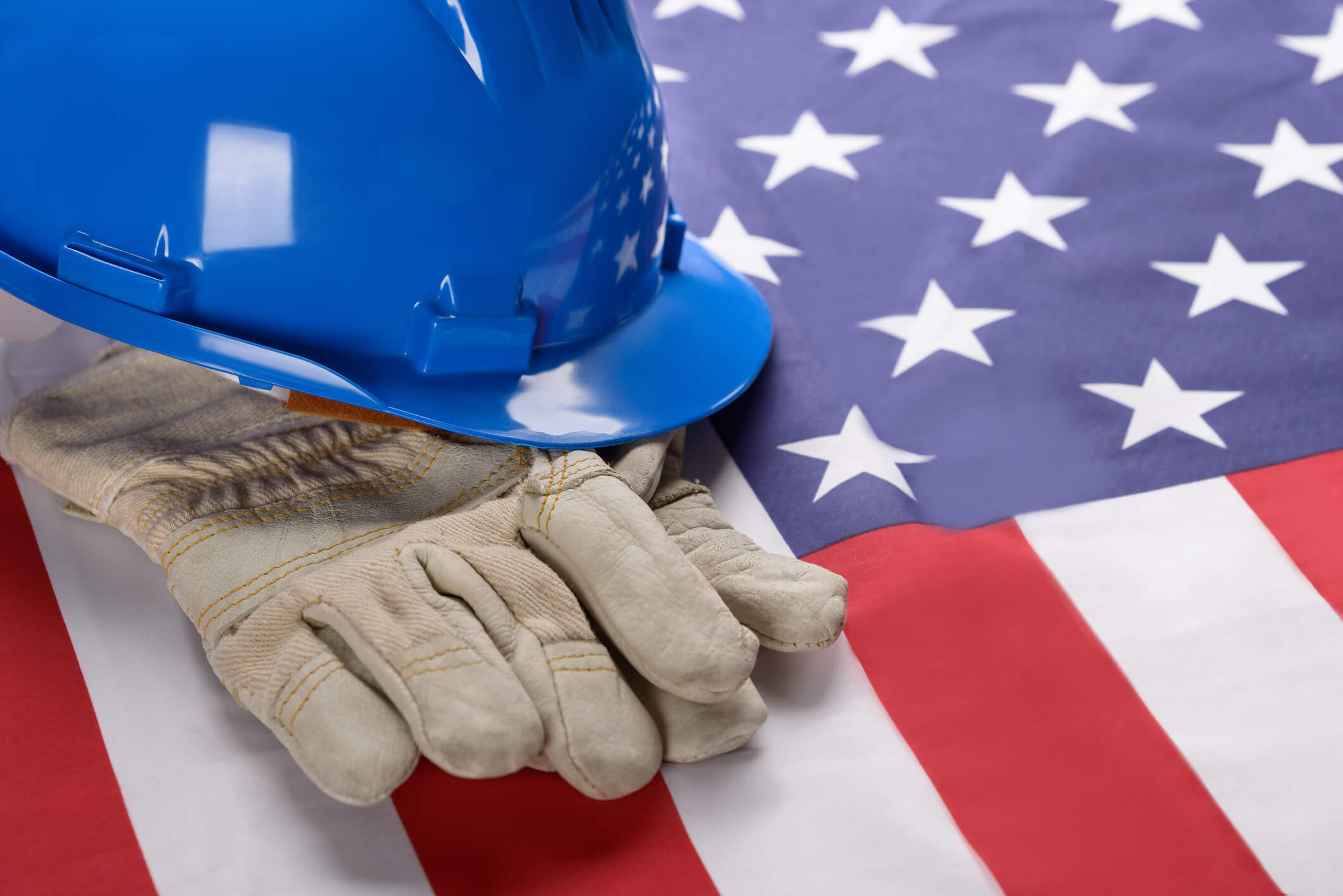 Close-up Of Blue Hardhat And Gloves On American Flag