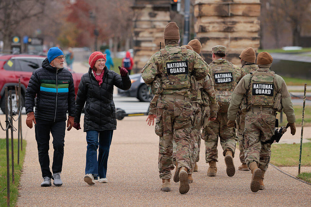 WASHINGTON, DC - DECEMBER 08: Tourists thank members of the National Guard as they patrol along the National Mall on December 08, 2025 in Washington, DC. President Donald Trump ordered an additional 500 National Guard troops to Washington following the shooting of two guardsmen from West Virginia on November 27. (Photo by Chip Somodevilla/Getty Images)