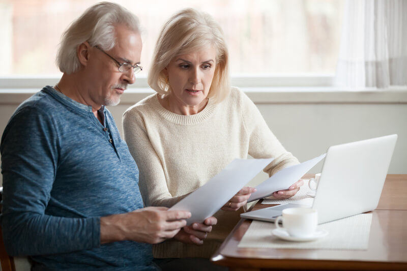 Serious worried senior couple reading documents calculating bill. Serious worried senior couple calculating bills to pay or checking domestic finances stressed of debt, retired elderly old family reading documents concerned about loan bankruptcy money problems