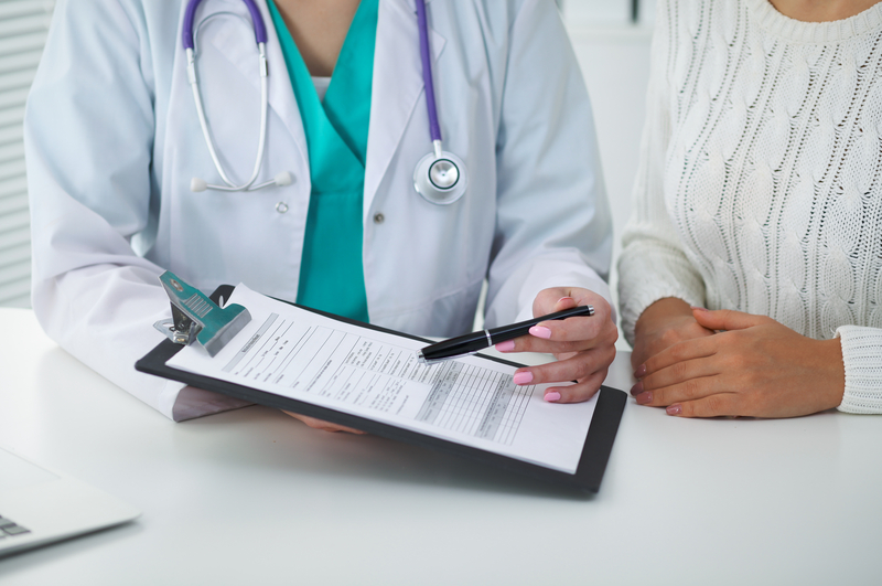 Doctor and patient, close-up of hands. Open enrollment for health insurance ends soon.