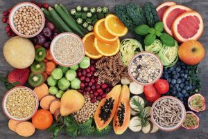 Health Food with High Fiber Content. Health food concept for a high fiber diet with fruit, vegetables, cereals, whole wheat pasta, grains, legumes and herbs. Foods high in anthocyanins, antioxidants, smart carbohydrates and vitamins on marble background top view.