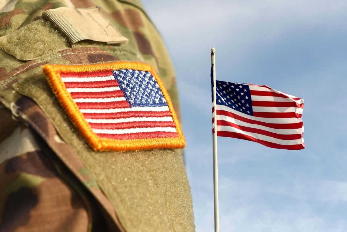 Veterans Day. US soldier. US army. Military of USA. US army uniform patch flag and Flag of USA weaving in the sky.