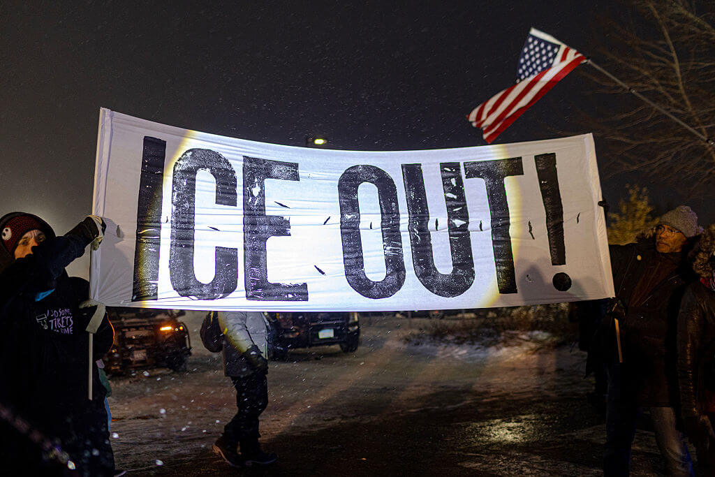 Protesters with a large anti-ICE sign, stand outside of the Henry Bishop Whipple Federal building on January 18, 2026 in Minneapolis, Minnesota.