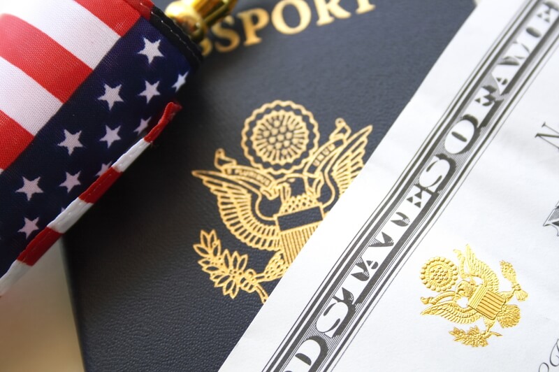 Immigration concept, US passport and flag over a citizenship and naturalization certificate