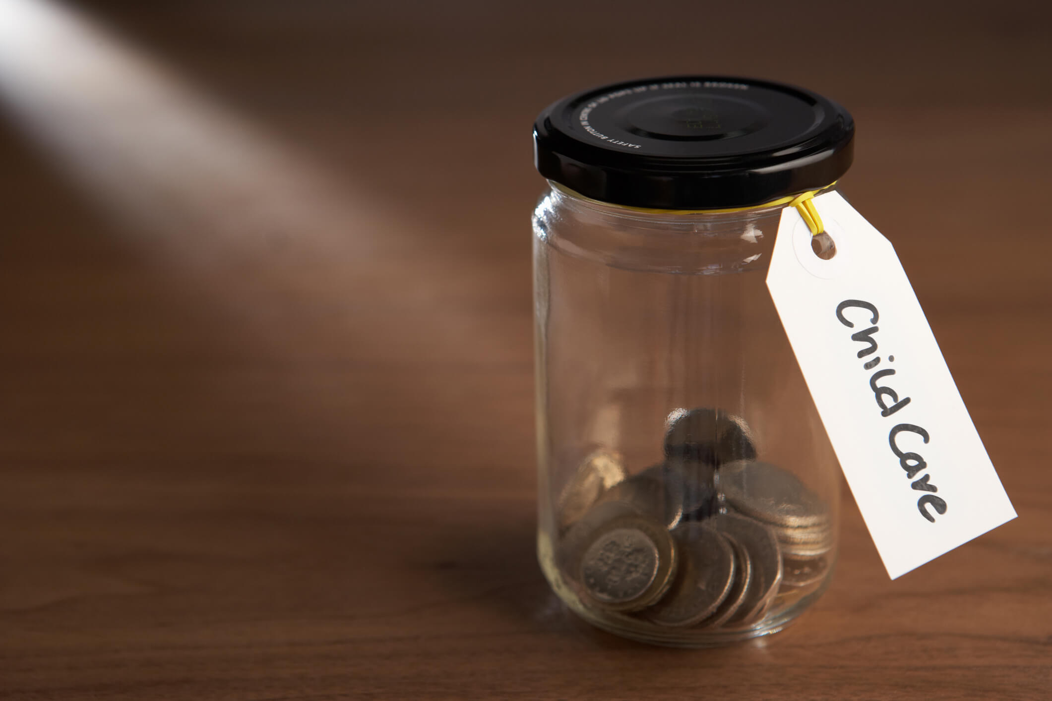 Coins in a jam jar with label saying child care