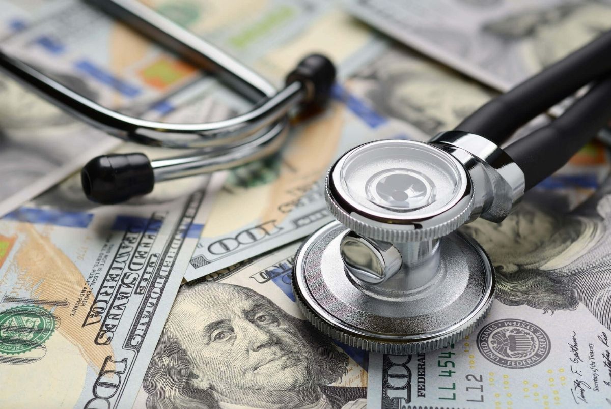 Medical stethoscope and dollar bills. Medical stethoscope on heap of dollar bills. Health care or insurance costs concept. Finance banking audit analytics.