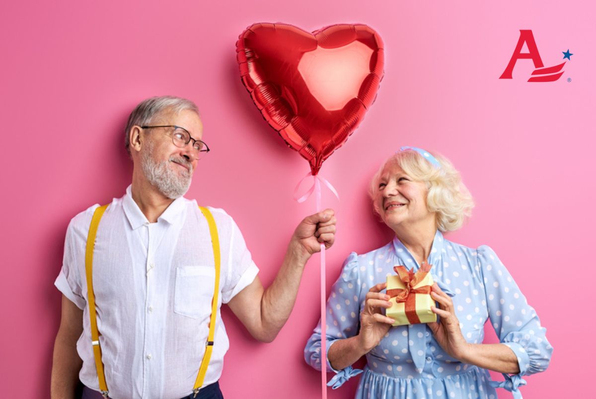 Senior couple celebrating Valentine's Day isolated on pink background. beautiful women and men in party clothes, holding gift box and air balloon in heart shape
