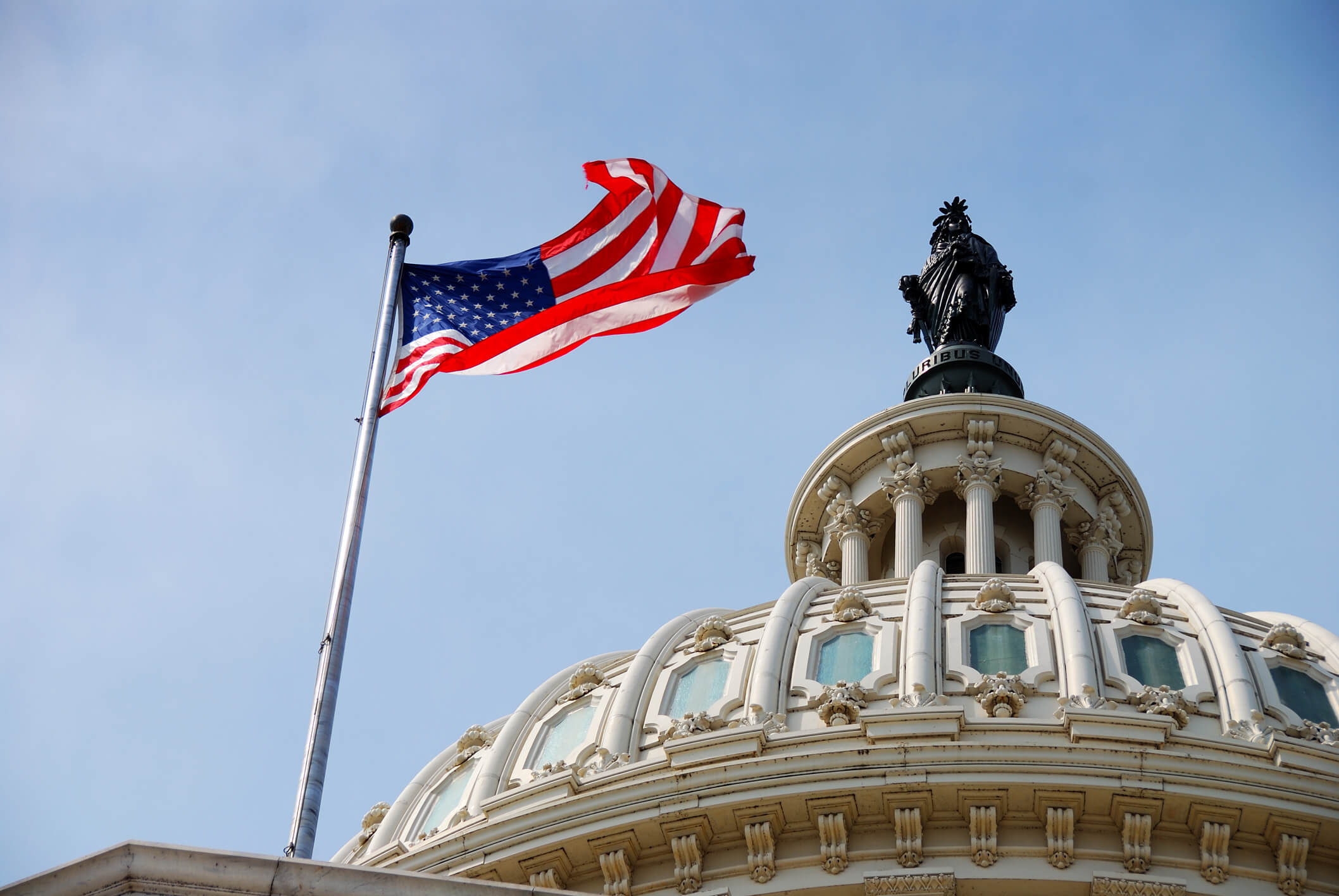 US Flag and Capitol building, Washington DC. US national flag flying over Capitol Hill Building in Washington DC