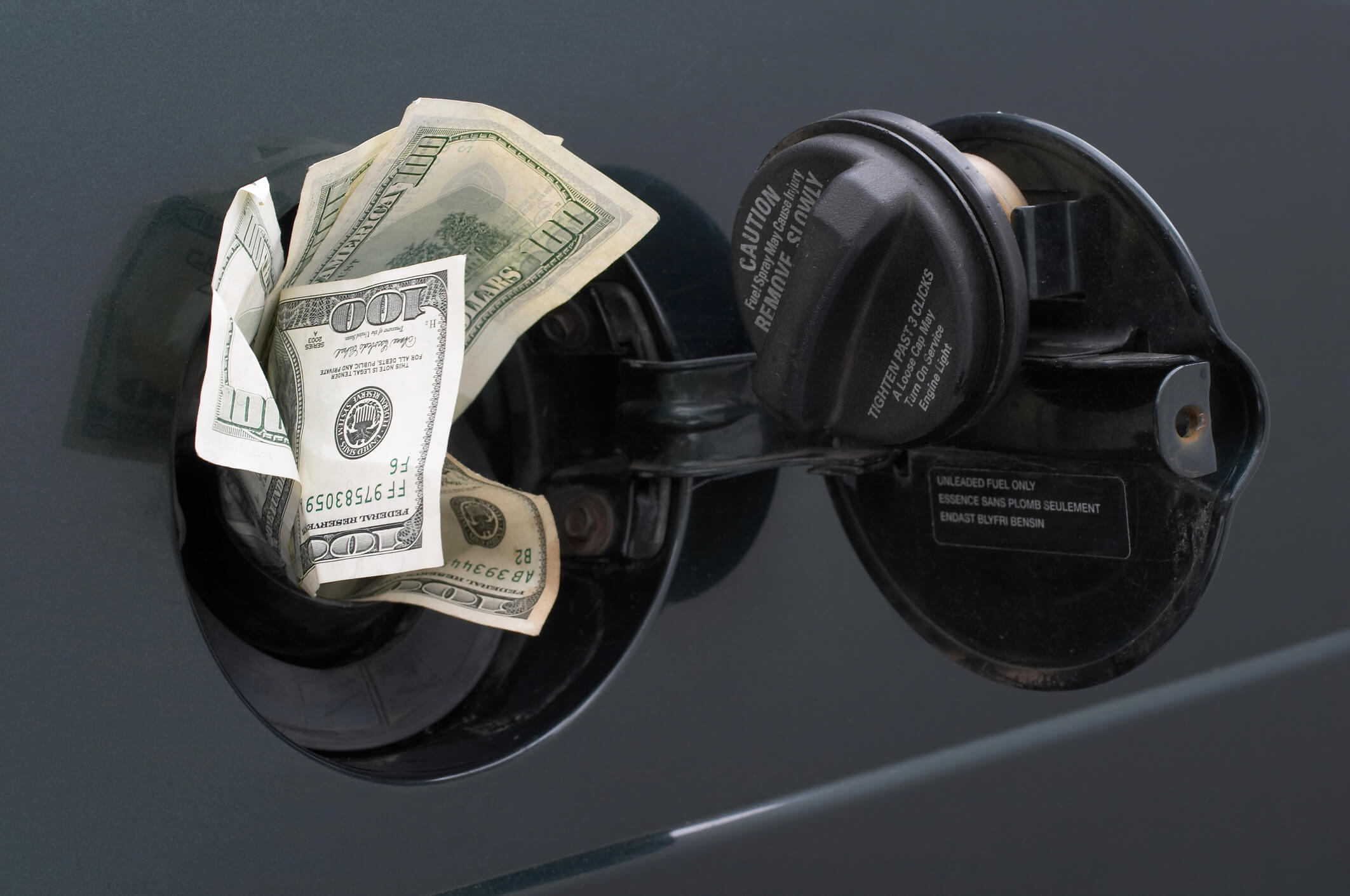 Rising gas prices. Image of american dollars in gasoline tank.