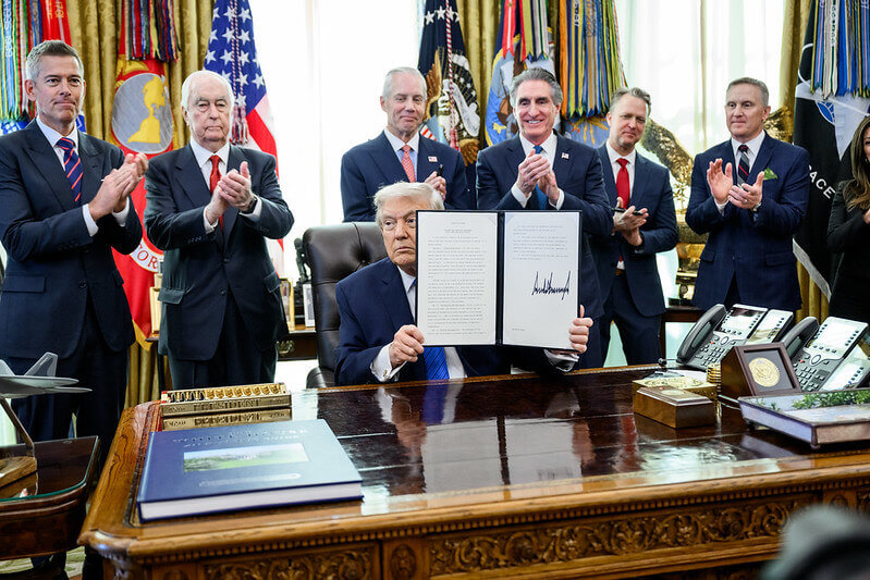 President Donald Trump signs an executive order bringing IndyCar racing to Washington, D.C., Friday, January 30, 2026, in the Oval Office. President Trump is joined by Secretary of Transportation Sean Duffy, Secretary of Interior Doug Burgum, Penske Corporation Chair Roger Penske, and Penske Corporation President Bud Denker.