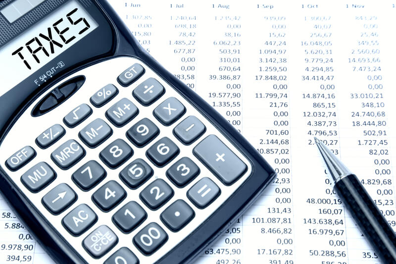 Calculator with TAXES text with calculation sheet background