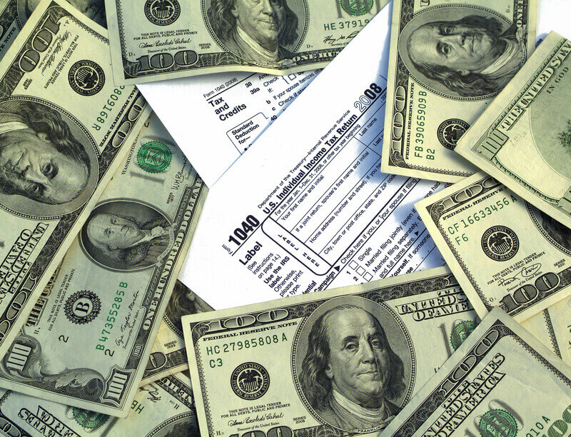 Government Tax Money. american Taxation concept: Blank financial 1040 taxes paperwork form surrounded by US 100 dollar bills.