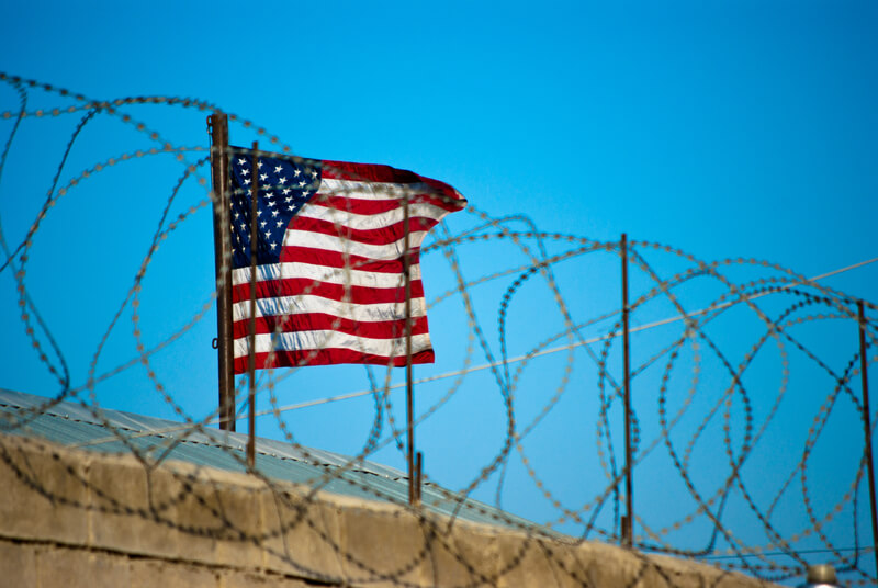 US Flag behind concertina wire